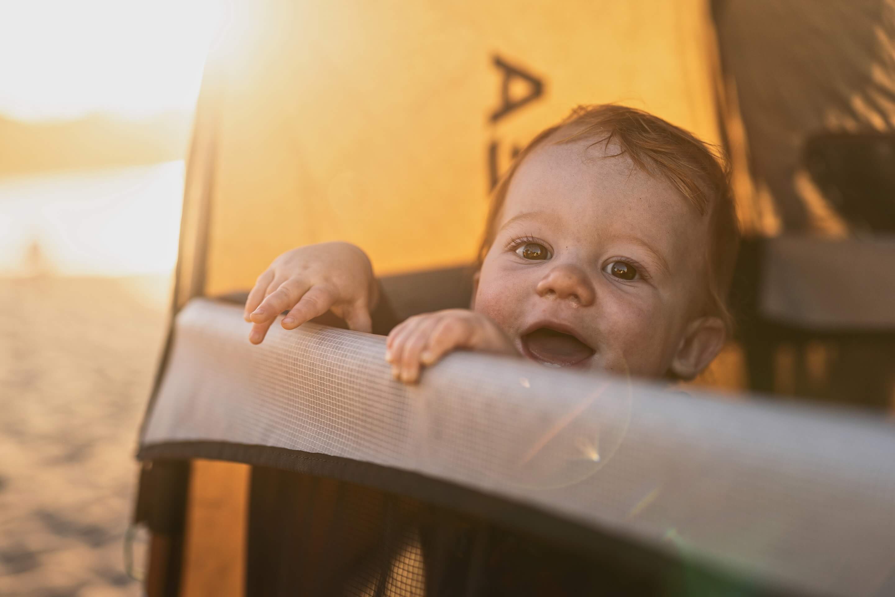 Baby on beach in Orea crib
